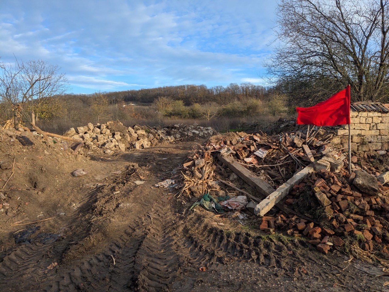 Cleared access path with demolition debris piles at the Kiten KOIVU site