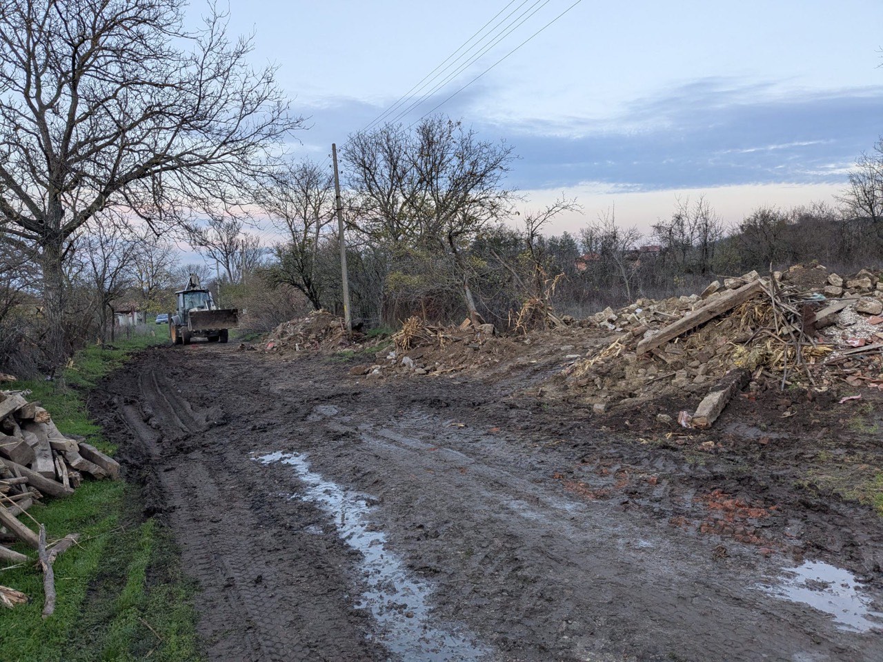 Cleared muddy access area with machinery after debris removal
